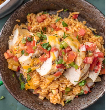 Grilled tequila lime chicken tenders over cheesy Mexican rice with pico de gallo