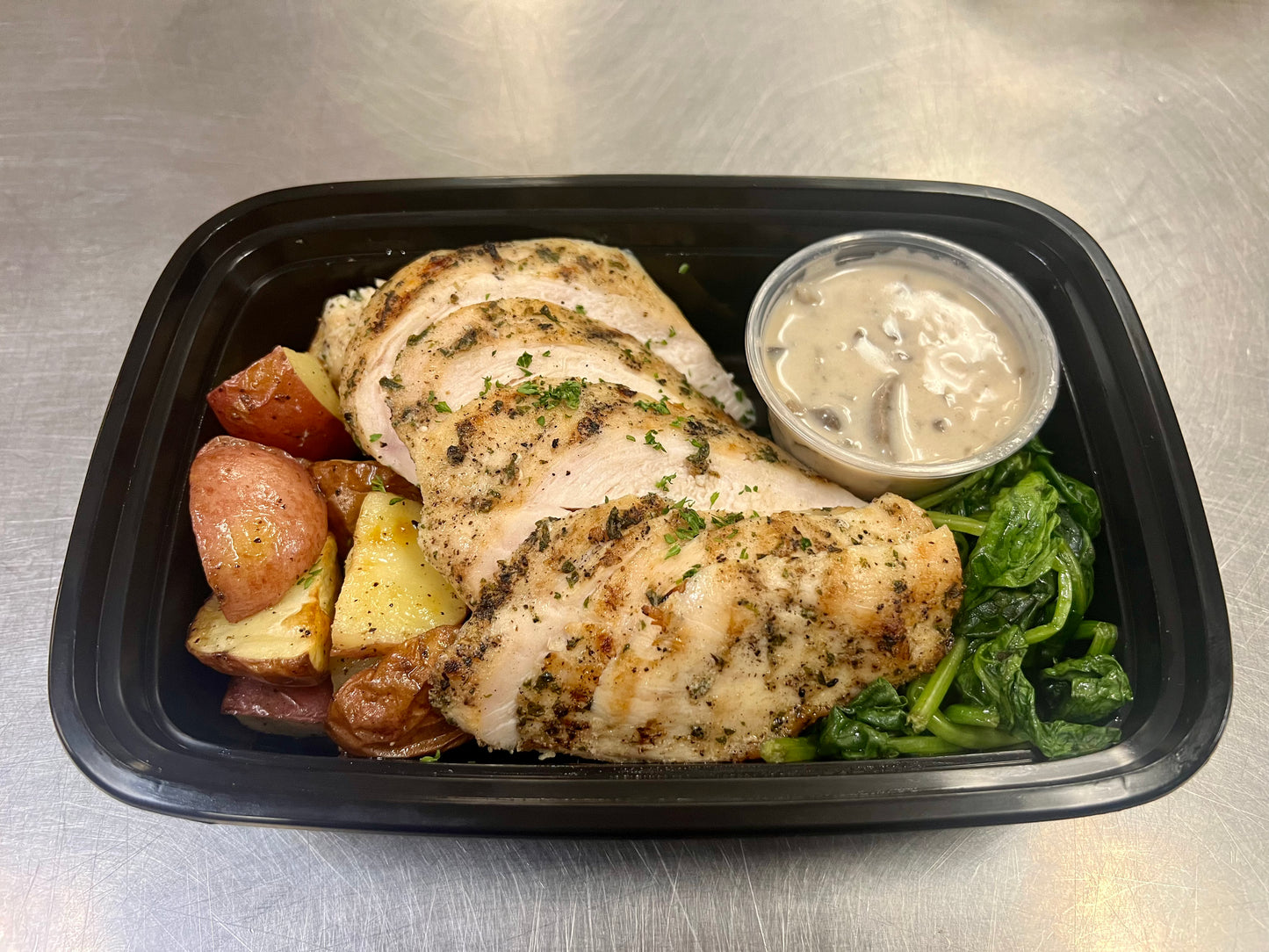 Grilled chicken with roasted potatoes, sauteed spinach & side of marsala wine sauce